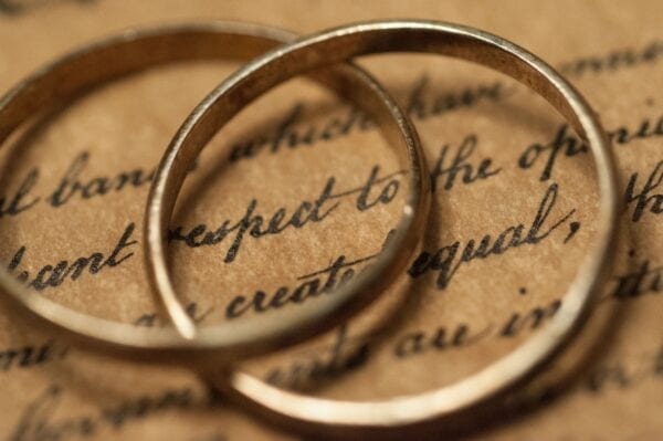 Two wedding rings sitting on top of a piece of paper.